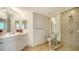 Well-lit bathroom with a glass-enclosed shower, vanity with sink, and neutral tile flooring at 800 N Tamiami Trl # 1506, Sarasota, FL 34236
