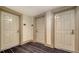 Hallway showing neutral-toned doors with bronze-colored hardware and striped carpeting at 800 N Tamiami Trl # 1506, Sarasota, FL 34236