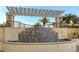 Multi-tiered stone water feature under a pergola, creating a serene outdoor focal point at 800 N Tamiami Trl # 1506, Sarasota, FL 34236