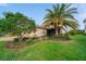 Home exterior with mature landscaping, green grass and brick driveway leading to the garage at 8007 River Preserve Dr, Bradenton, FL 34212