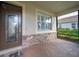 Charming front porch with decorative glass door, brick accents, and a screen enclosure at 8007 River Preserve Dr, Bradenton, FL 34212