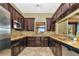 Community kitchen featuring dark wood cabinets, granite countertops, stainless steel appliances, and tile flooring at 8007 River Preserve Dr, Bradenton, FL 34212
