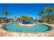 Community pool featuring a center island with three large blue potted plants, surrounded by lounge chairs at 8007 River Preserve Dr, Bradenton, FL 34212