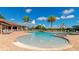 Beautiful community pool and lounge area surrounded by palm trees, lounge chairs, and umbrellas at 8007 River Preserve Dr, Bradenton, FL 34212