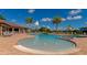 Beautiful community pool and lounge area surrounded by palm trees, lounge chairs, and umbrellas at 8007 River Preserve Dr, Bradenton, FL 34212