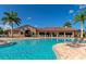 Beautiful community pool and clubhouse area featuring lounge chairs, palm trees, and ample shade at 8007 River Preserve Dr, Bradenton, FL 34212