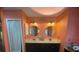 Bright bathroom with dual sinks, round mirrors, and modern lighting fixtures at 810 Hammockwood Ct, Sarasota, FL 34232