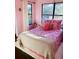 Cozy bedroom featuring a floral-patterned bedspread and bright natural light at 810 Hammockwood Ct, Sarasota, FL 34232