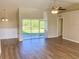 Spacious living room with hardwood floors, ceiling fan, and sliding glass doors to the patio at 8314 Drolet Ave, North Port, FL 34291