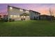 A wide backyard with lush grass at sunset featuring a covered patio and black metal fence at 8330 Abalone Loop, Parrish, FL 34219