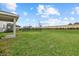 A spacious backyard with lush grass, a black metal fence, and a trampoline on a sunny day at 8330 Abalone Loop, Parrish, FL 34219