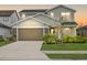 Two story home featuring a two car garage and a well manicured lawn at 8330 Abalone Loop, Parrish, FL 34219