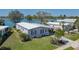 Aerial view of a home with a well-manicured lawn, mature trees, and a waterfront view at 8409 Imperial Cir, Palmetto, FL 34221