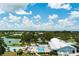 Aerial view of a community pool area with sparkling pools, tiki huts, lounge chairs, and well-manicured landscaping at 8409 Imperial Cir, Palmetto, FL 34221
