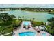 Scenic aerial view of a community pool area by the lake with tiki huts, pools, and seating for relaxation at 8409 Imperial Cir, Palmetto, FL 34221