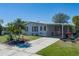 Well-kept front yard with landscaped beds, a carport, and an inviting facade at 8409 Imperial Cir, Palmetto, FL 34221