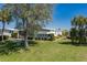 Beautifully landscaped yard showcasing a well-maintained home with manicured bushes, trees, and lush green grass at 8409 Imperial Cir, Palmetto, FL 34221