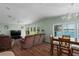 Inviting living room featuring wood floors, large windows with lake views, and comfortable seating and dining area at 8409 Imperial Cir, Palmetto, FL 34221