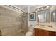 Well-lit bathroom featuring a glass enclosed shower and vanity with a framed mirror at 850 S Tamiami Trl # 307, Sarasota, FL 34236