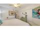 Bright bedroom boasts white bedding, decorative dresser, and ceiling fan at 850 S Tamiami Trl # 307, Sarasota, FL 34236