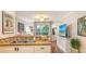 Open kitchen with breakfast bar, updated appliances and view of lanai at 850 S Tamiami Trl # 307, Sarasota, FL 34236