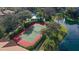 An aerial shot showcases a well-maintained tennis court near a serene pond with a fountain at 850 S Tamiami Trl # 307, Sarasota, FL 34236