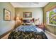 Bedroom with green walls, bamboo bed frame, ceiling fan, and natural light at 9441 Discovery Ter # 101A, Bradenton, FL 34212