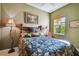 Bedroom with green walls, bamboo bed frame, ceiling fan, and natural light at 9441 Discovery Ter # 101A, Bradenton, FL 34212