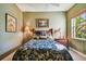 Comfortable bedroom featuring tropical themed bedding, light green walls, and natural light from the window at 9441 Discovery Ter # 101A, Bradenton, FL 34212