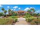 Inviting clubhouse exterior surrounded by manicured landscaping and swaying palm trees at 9441 Discovery Ter # 101A, Bradenton, FL 34212