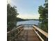 A wooden dock extends toward a tranquil body of water surrounded by lush greenery under a serene sky at 9441 Discovery Ter # 101A, Bradenton, FL 34212