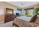 Tranquil main bedroom with dresser, comfy queen size bed, and lots of light from the large windows at 9441 Discovery Ter # 101A, Bradenton, FL 34212