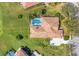 Overhead shot of a home's roof, driveway, and the well-manicured lawn, bushes, and trees surrounding it at 9612 Old Hyde Park Pl, Bradenton, FL 34202