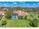 Aerial view of a home showcasing a screened-in pool and lush green backyard under a clear blue sky at 9612 Old Hyde Park Pl, Bradenton, FL 34202