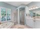 Well-lit bathroom featuring a jacuzzi tub, large shower, and double vanity at 9612 Old Hyde Park Pl, Bradenton, FL 34202
