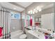 Bright bathroom with tiled shower, vanity with mirror, and a window for natural light at 9612 Old Hyde Park Pl, Bradenton, FL 34202