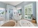 Bright bathroom features double sinks, soaking tub under plantation shutters, and tiled floors at 9612 Old Hyde Park Pl, Bradenton, FL 34202