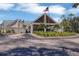 Golf clubhouse featuring an entrance, American flag, and palm trees, set against a blue sky at 9612 Old Hyde Park Pl, Bradenton, FL 34202