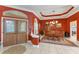 Elegant dining room with tray ceiling, chandelier, wood table and chairs, set against striking red walls at 9612 Old Hyde Park Pl, Bradenton, FL 34202