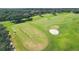 Expansive aerial view of a lush green golf course with sand traps and mature trees in a serene community at 9612 Old Hyde Park Pl, Bradenton, FL 34202