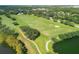 Panoramic view of a well-manicured golf course with lush green fairways, trees, and a serene pond, providing a picturesque landscape at 9612 Old Hyde Park Pl, Bradenton, FL 34202