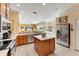 Well-lit kitchen with stainless appliances, kitchen island and view of living room and pool at 9612 Old Hyde Park Pl, Bradenton, FL 34202