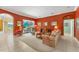 Cozy living room featuring a floral sofa, entertainment center, and a seamless connection to the outdoor patio at 9612 Old Hyde Park Pl, Bradenton, FL 34202