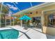 A covered patio features an outdoor dining set, a ceiling fan, and views of a screened-in pool at 9612 Old Hyde Park Pl, Bradenton, FL 34202