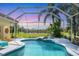 Relaxing screened-in pool and spa overlooking a serene lake, perfect for enjoying tranquil outdoor living at 9612 Old Hyde Park Pl, Bradenton, FL 34202