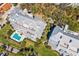 Aerial view of condos featuring a pool, waterfront views, parking, and lush landscaping at 1000 Riverside Dr # B102, Palmetto, FL 34221