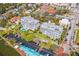 Aerial view of condos with a pool, lush landscaping, parking, and nearby buildings at 1000 Riverside Dr # B102, Palmetto, FL 34221