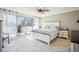 Bright main bedroom featuring a large bed, access to a balcony, and tile flooring at 1000 Riverside Dr # B102, Palmetto, FL 34221