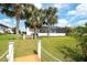 Rear of the home featuring a screened-in lanai, walkway to a dock, lush landscaping and serene water views at 11511 Harbourside Ln, Parrish, FL 34219