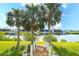 Picturesque backyard showcasing manicured lawn, palm trees, a private dock, and serene waterfront views at 11511 Harbourside Ln, Parrish, FL 34219